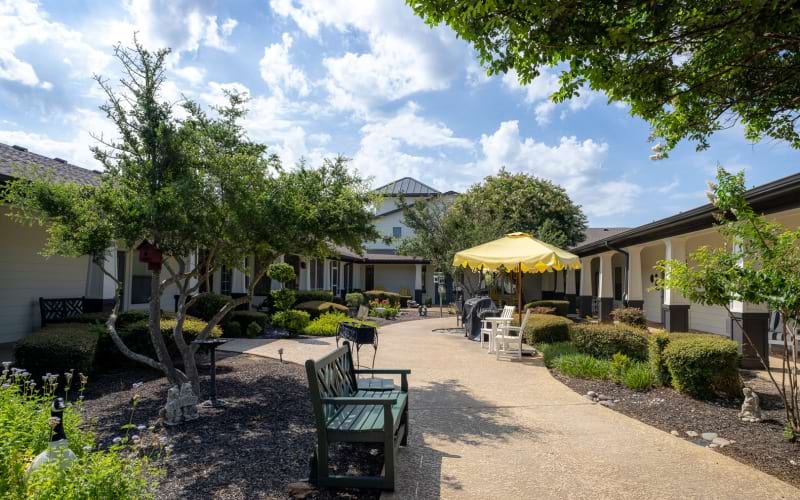 Outdoor couryard with tables, benches, and umbrella
